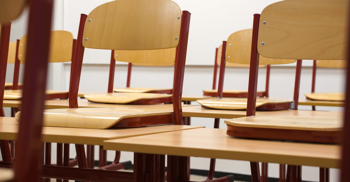 A modern and empty classroom featuring wooden chairs and desks with a focus on education and learning spaces.